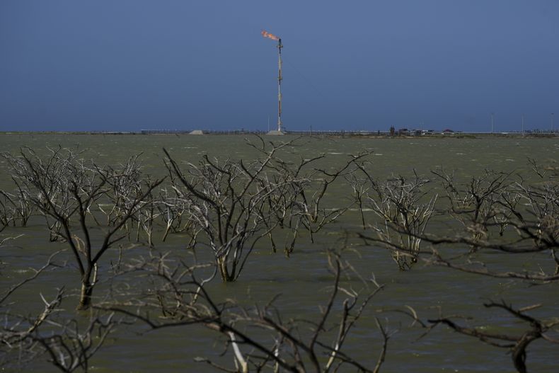 Una compañía de gas opera cerca de árboles sumergidos en Manaure, Colombia, el jueves 6 de febrero de 2025. (AP Foto/Iván Valencia)