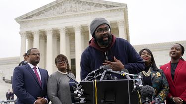 Evan Milligan (cent), quien presentó la demanda en el caso del mapa electoral de Alabama, frente a la Corte Suprema en Washington, el 4 de octubre de 2022. (Foto AP /Patrick Semansky)