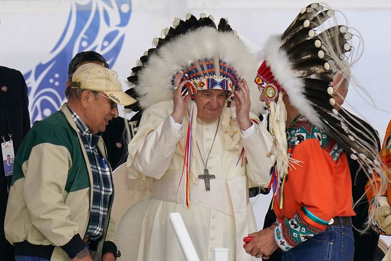 ARCHIVO – El papa Francisco se pone un penacho durante una visita a los pueblos indígenas de Maskwaci, la antigua escuela residencial Ermineskin, el lunes 25 de julio de 2022, en Maskwacis, Alberta. (AP Foto/Eric Gay, Archivo)