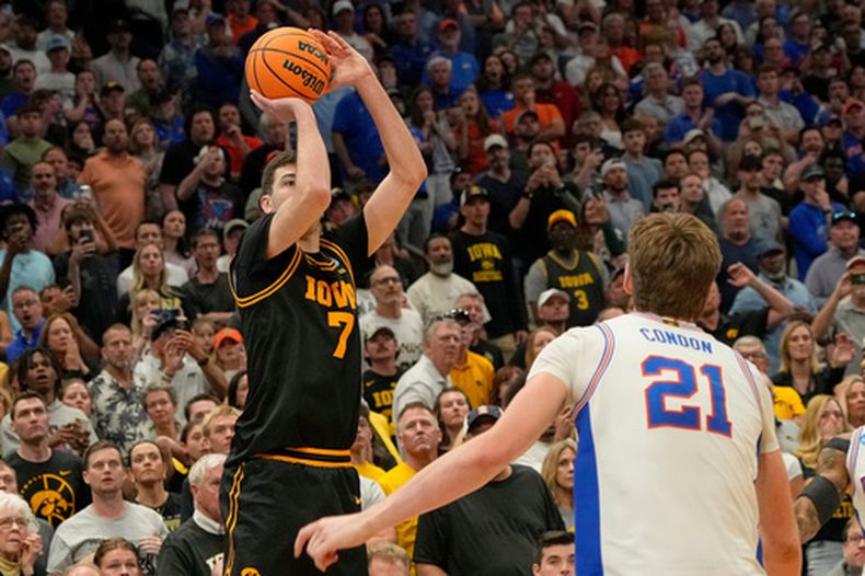 Álvaro Folgueiras (7) de Iowa encesta el triple para vencer a Florida en el partido de la segunda ronda del torneo de baloncesto universitario de la NCAA, el domingo 22 de marzo de 2026, en Tampa, Florida. (AP Foto/John Raoux)