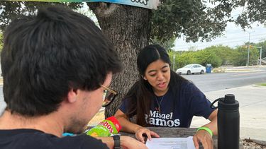 Esta fotografía, tomada con un teléfono inteligente, muestra a dos miembros de los Socialistas Democráticos de Estados Unidos, Mark Ramirez y Clarisse Manuel, durante una jornada de contacto con los votantes el sábado 26 de septiembre de 2026, en Austin, Texas. (AP Foto/Jesse Bedayn)