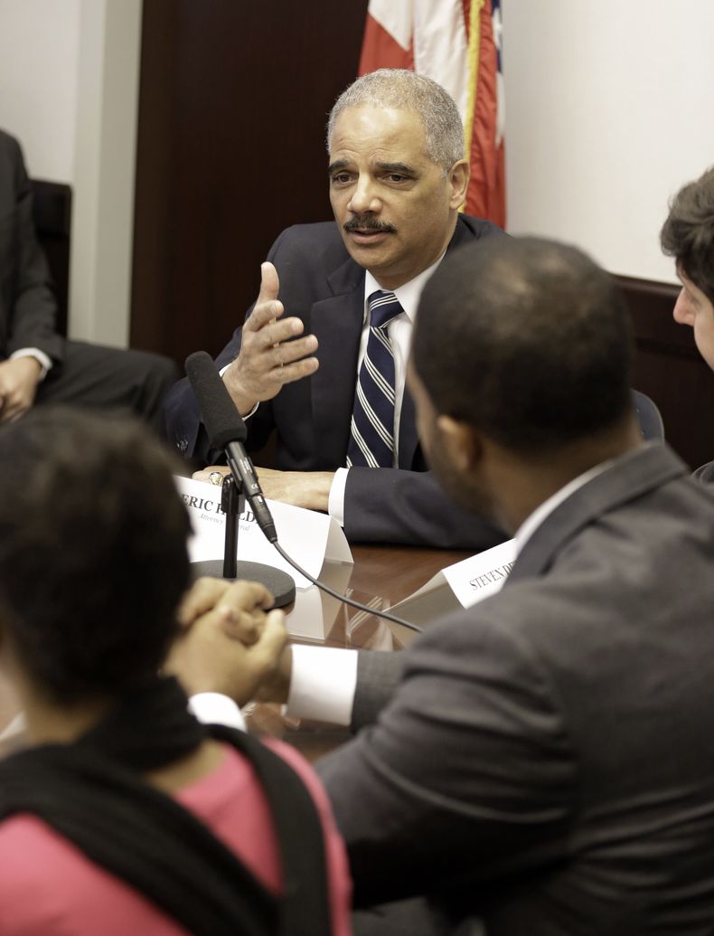 El secretario de Justicia de Estados Unidos Eric Holder, derecha, es visto durante una mesa redonda con representantes de la polic&iacute;a, funcionarios locales y l&iacute;deres comunitarios en Cleveland el jueves, 4 de diciembre del 2014. (Foto AP/Tony