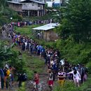Migrantes que buscan llegar a Estados Unidos hacen fila para tomar un bote en Bajo Chiquito, en la provincia de Darién en Panamá, el jueves 5 de octubre de 2023, después de caminar a través de la selva del Darién desde Colombia. (AP Foto/Arnulfo Franco)