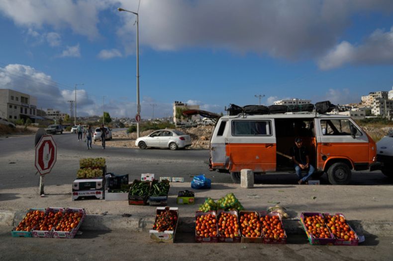 ARCHIVO - Un vendedor callejero palestino espera a clientes mientras expone frutas y verduras en el mercado semanal a las afueras de la ciudad de Nablús, Cisjordania, el 16 de septiembre de 2024. (AP Foto/Nasser Nasser, Archivo)