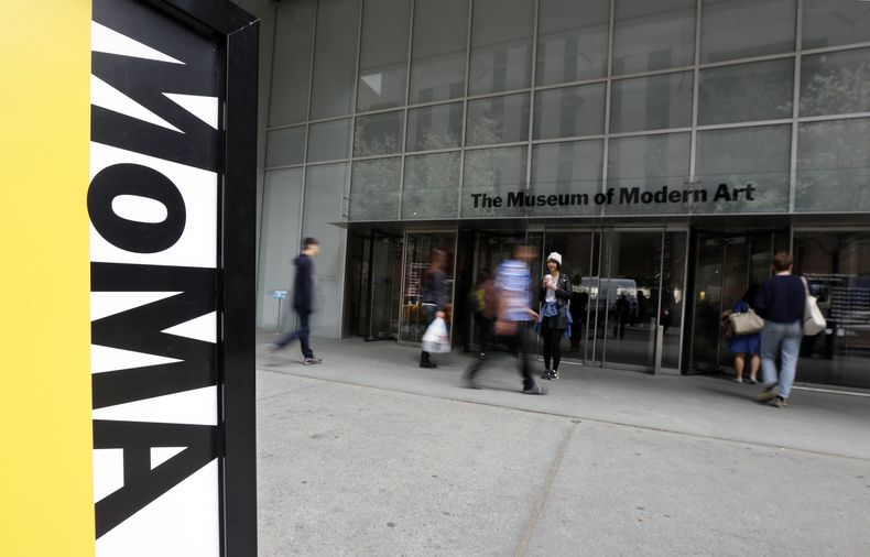 ARCHIVO- Personas caminan frente a la entrada del Museo de Arte Moderno en Nueva York, el 22 de abril de 2014. Un artista que participó desnudo en una retrospectiva de la artista Marina Abramovic en el museo presentó una demanda argumentando que la institución no emprendió medidas después de que fue agredido sexualmente varias veces por personas del público. La demanda fue presentada en Manhattan el 22 de enero de 2024. (Foto AP/Richard Drew, archivo)