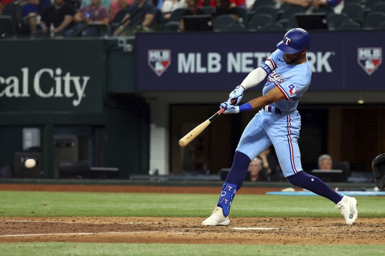 Leody Taveras, de los Rangers de Texas, batea sencillo para impulsar la carrera de le ventaja en contra de los Azulejos de Toronto en la quinta entrada del juego de béisbol, el domingo 18 de junio de 2023, en Arlington, Texas. (AP Foto/Richard W. Rodriguez)