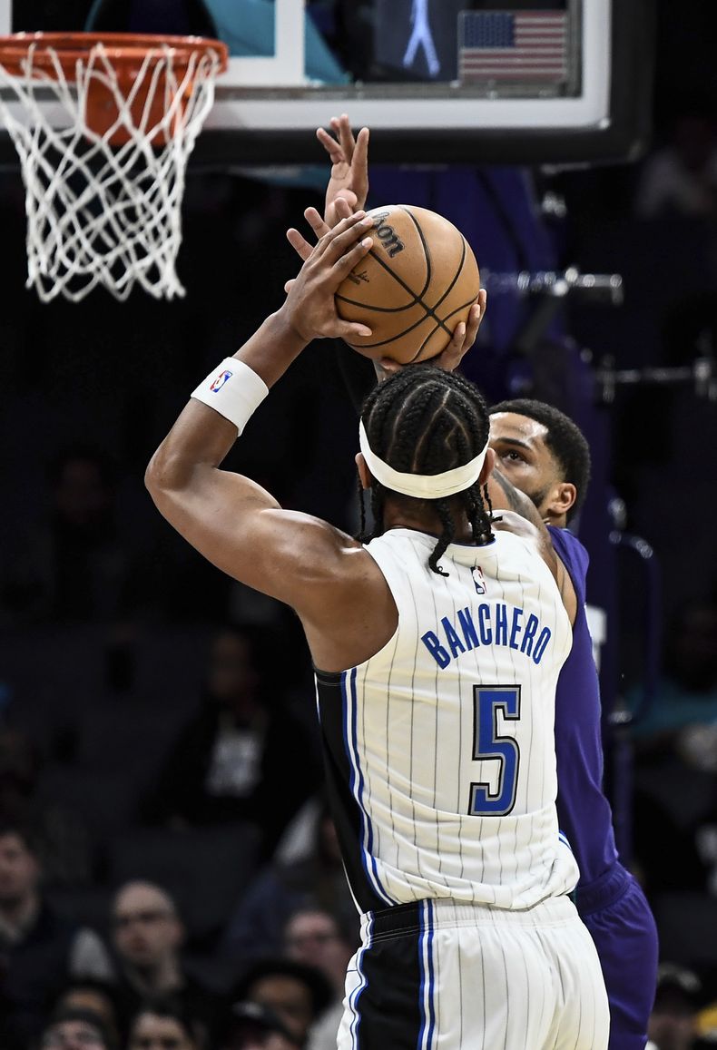 El alero de los Hornets de Charlotte Miles Bridges intenta bloquear el tiro del alero del Magic de Orlando Paolo Banchero en el encuentro de la NBA del martes 5 de marzo del 2024. (AP Foto/Matt Kelley)