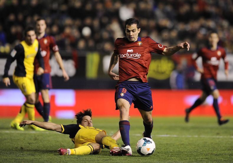 Koke, del Atl&eacute;tico de Madrid, se barre para tratar de quitar el bal&oacute;n al argentino Emiliano Armenteros, del Osasuna, durante su juego de la liga espa&ntilde;ola de f&uacute;tbol de primera divisi&oacute;n, el domingo 23 de febrero de 2014, e