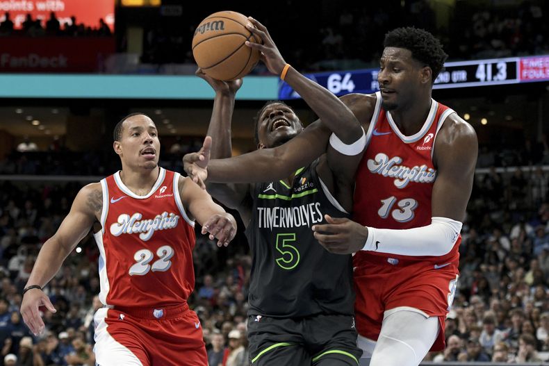 Anthony Edwards, base de los Timberwolves de Minnesota, controla un balón entre Jaren Jackson y Desmond Bane, de los Grizzlies de Memphis, en el duelo del jueves 10 de abril de 2025 (AP Foto/Brandon Dill)