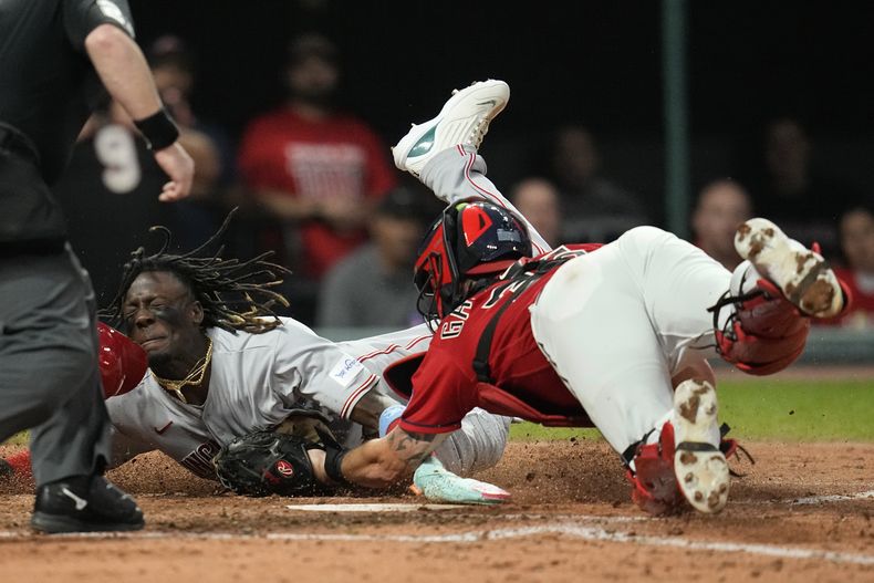 Elly De La Cruz, izquierda, de los Rojos de Cincinnati, es retirado en el plato por el receptor de los Guardianes de Cleveland, Cam Gallagher, durante la quinta entrada del juego de béisbol del miércoles 27 de septiembre de 2023, en Cleveland. (AP Foto/Sue Ogrocki)