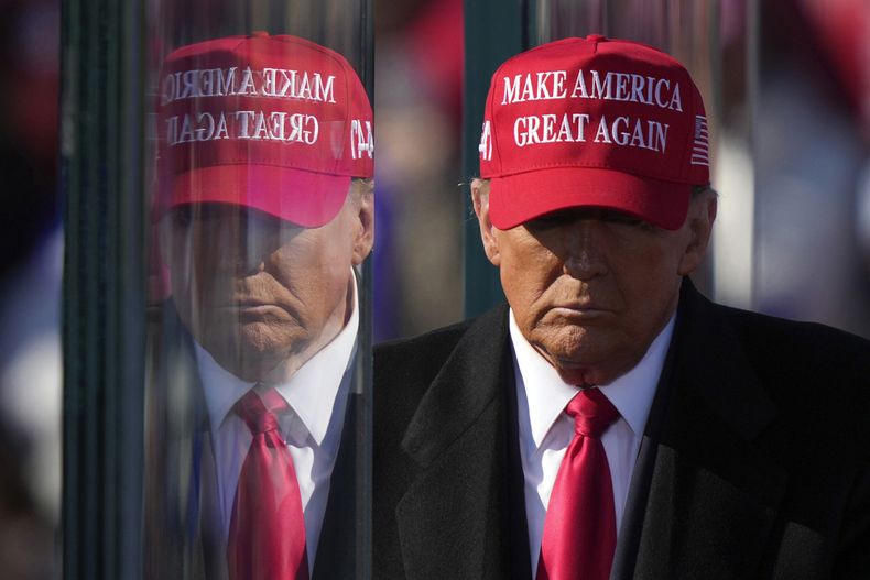 El expresidente y candidato Donald Trump reflejado en un cristal antibalas al final de su intervención en un acto de campaña en Lititz, Pensilvania, el domingo 3 de noviembre de 2024. (AP Foto/Matt Rourke)