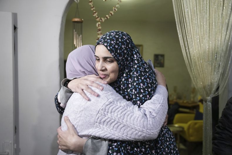 Marah Bakir (derecha), una expresa palestina liberada por las autoridades israelíes, es recibida por sus parientes en la vivienda familiar en el vecindario de Beit Hanina, en Jerusalén Este, el 24 de noviembre de 2023. (AP Foto/Mahmoud Illean)