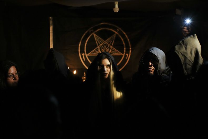 ARCHIVO - Satariel, en el centro, miembro del Templo de Satán: Satanistas y Luciferinos de Chile, participa en una celebración pagana celta en Santiago, Chile, el 31 de octubre de 2024. (AP Foto/Esteban Félix, Archivo)