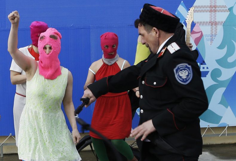 Un miliciano cosaco, derecha, golpea con un l&aacute;tigo a integrantes del grupo punk Pussy Riot el mi&eacute;rcoles, 19 de febrero de 2014, en Sochi, Rusia. (AP Photo/Morry Gash)