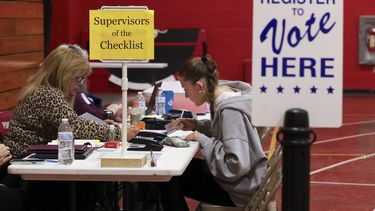 La supervisora de la lista de control del estado de Nueva Hampshire Leslie Dombroski, a la izquierda, inscribe a Elise Collins, de 18 años, para votar en Derry, Nueva Hampshire, el martes 11 de marzo de 2025. (AP foto/Reba Saldanha)