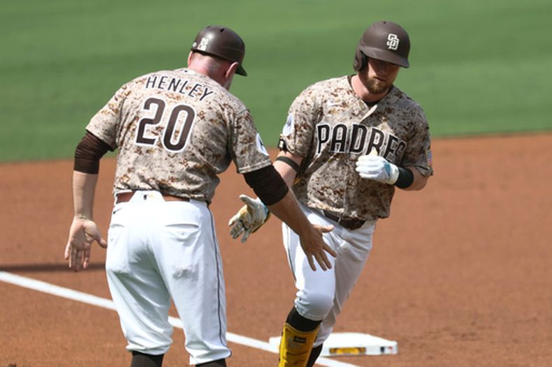 Jake Cronenworth, de los Padres de San Diego (derecha), celebra con el coach de tercera base Bob Henley (izquierda), tras conectar un jonrón de dos carreras en la segunda entrada de un partido de béisbol contra los Marlins de Miami, el domingo 20 de septiembre de 2026, en San Diego. (Foto AP/Karl Anderson)