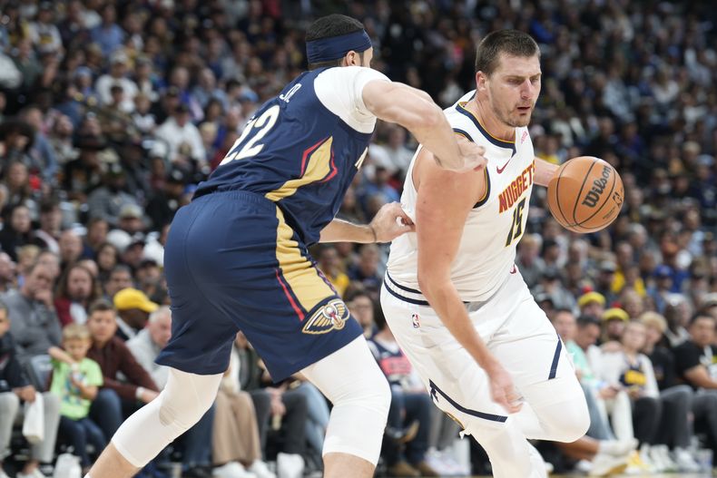 El jugador de los Nuggets de Denver Nikola Jokic (derecha), trata de superar a su rival de los Pelicans de Nueva Orleans Larry Nance Jr. (izquierda), durante el juego de la NBA que enfrentó a ambos equipos, el 6 de noviembre de 2023, en Denver. (AP Foto/David Zalubowski)