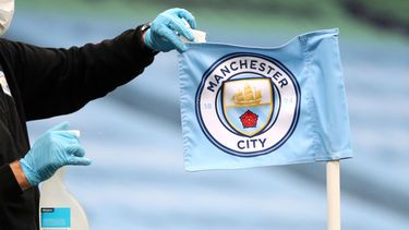 ARCHIVO - Un empleado limpia el banderín de córner previo al partido entre Manchester City y Burnley en la Liga Premier, el lunes 22 de junio de 2020. (AP Foto/Martin Rickett)