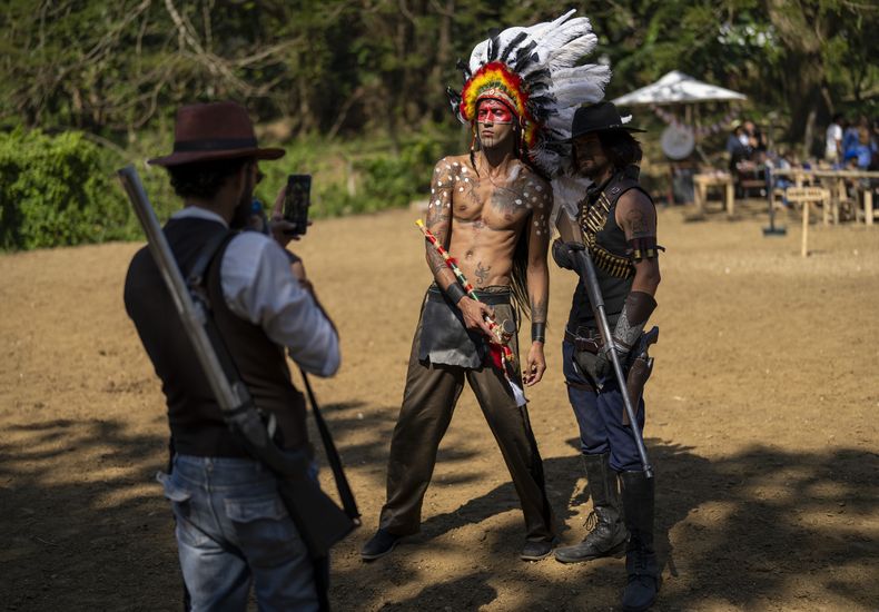 Dos cosplayers posan para una foto en una fiesta temática del lejano oeste organizada por la productora SuZume, en una finca en las afueras de La Habana, el sábado 1 de febrero de 2025. (AP Foto/Ramón Espinosa)