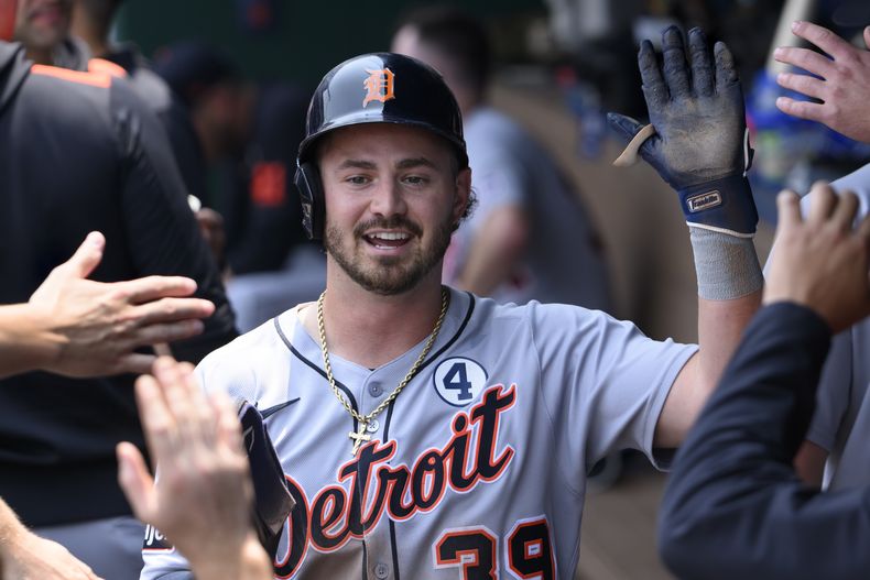 Zach McKinstry, de los Tigres de Detroit, es felicitado después de anotar por un lanzamiento descontrolado durante la tercera entrada contra los Reales de Kansas City, en Kansas City, Misuri, el domingo 1 de junio de 2025. (Foto AP/Reed Hoffmann)
