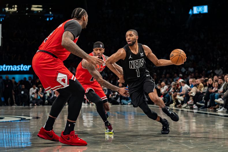 Mikal Bridges (1), de los Nets de Brooklyn, lleva el balón a la canasta contra Andre Drummond, izquierda, de los Bulls de Chicago, durante la segunda mitad del juego de baloncesto de la NBA, en Nueva York, el viernes 29 de marzó de 2024. (AP Foto/Peter K. Afriyie)
