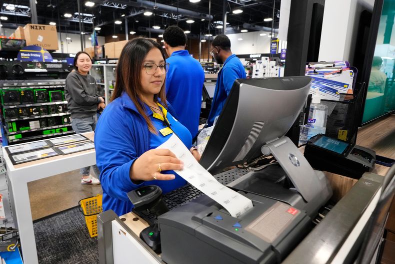 Abril Renteria, asesora certificada de Apple, ayuda a un cliente a terminar su compra en una tienda Best Buy, el miércoles 26 de noviembre de 2025, en Dallas. (AP Foto/Tony Gutierrez)