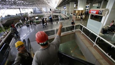 americateve | En esta fotograf&iacute;a del 28 de noviembre de 2013, dos trabajadores bajan por una escalera en el aeropuerto internacional de Brasilia, Brasil, el 28 de noviembre de 2013. La econom&iacute;a brasile&ntilde;a tuvo una contracci&oacute;n en el tercer tri