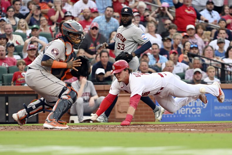 Nolan Gorman (16), de los Cardenales de San Luis, se barre en el plato y llega safe, durante la primera entrada en contra de los Astros de Houston del juego de béisbol, el miércoles 28 de junio de 2023, en San Luis. (AP Photo/Michael Thomas)