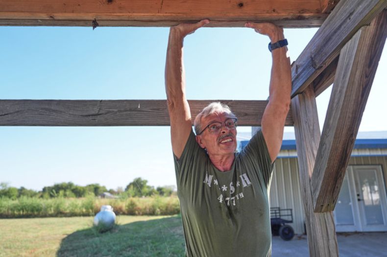 Ed Westrick, de 59 años, trabaja en el tejado de un edificio pequeño en su vivienda en una zona rural cerca de Commerce, Texas, el viernes 18 de septiembre de 2026. (AP Foto/LM Otero)