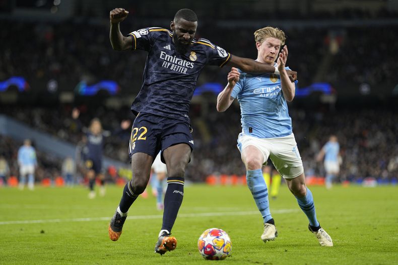 Kevin De Bruyne (derecha) del Manchester City pugna el balón con Antonio Rudiger del Real Madrid en el partido de vuelta de los cuartos de final de la Liga de Campeones, el miércoles 17 de abril de 2024, en Manchester. (AP Foto/Dave Shopland)