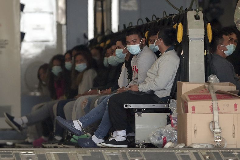 ARCHIVO - Migrantes con mascarillas y grilletes en las manos y los pies, sentados en un avión militar en Fort Bliss, en El Paso, Texas, el 30 de enero de 2025, a la espera de ser deportados a Guatemala. (AP Foto/Christian Chavez, archivo)