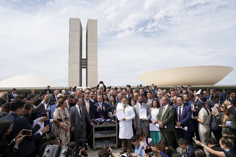 Senadores y diputados aliados del expresidente de Brasil Jair Bolsonaro ofrecen una conferencia de prensa en el exterior de la Asamblea Nacional, en Brasilia, el 5 de agosto de 2025, para denunciar la orden de arresto domiciliario emitida por el juez del Supremo Tribunal Alexandre de Moraes contra el exmandatario. (AP Foto/Eraldo Peres)