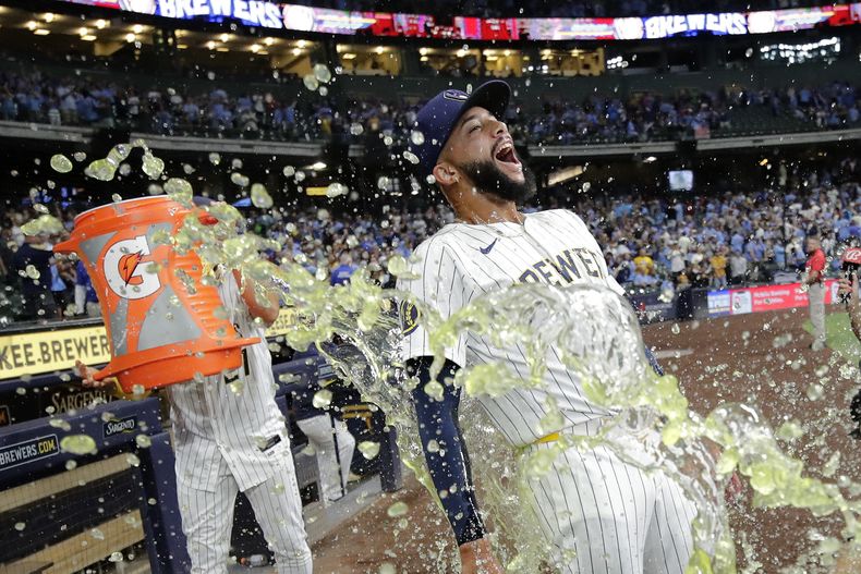 Devin Williams de los Cerveceros de Milwaukee es bañado por el dominicano Willy Adames tras la victoria ante los Rojos de Cincinnati el sábado 10 de agosto del 2024. (AP Foto/Aaron Gash)