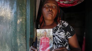 ARCHIVO - Rose Wanyua Wanjiku, hermana mayor de Agnes Wanjiru, de 20 años, sostiene una fotografía de Agnes, en la casa de Rose en el asentamiento informal de Majengo en Nanyuki, Kenia, el jueves 4 de noviembre de 2021. (AP Foto/Brian Inganga)