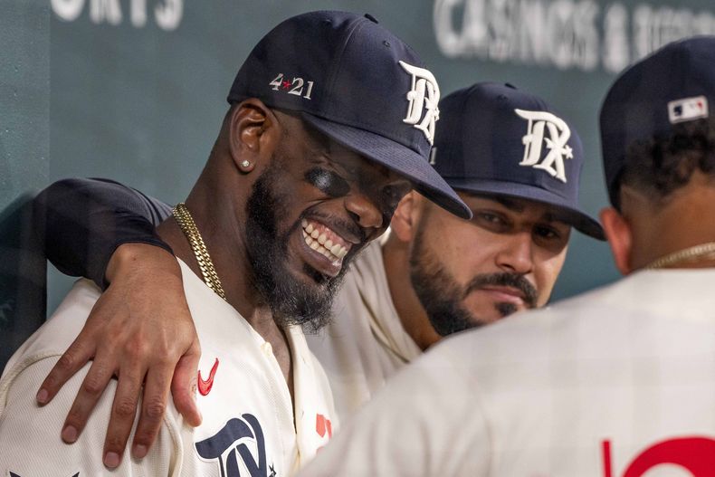 El cubano Adolis García, de los Rangers de Texas, ríe con sus compañeros antes de un juego ante los Guardianes de Cleveland, el sábado 15 de julio de 2023 (AP Foto/Emil T. Lippe)