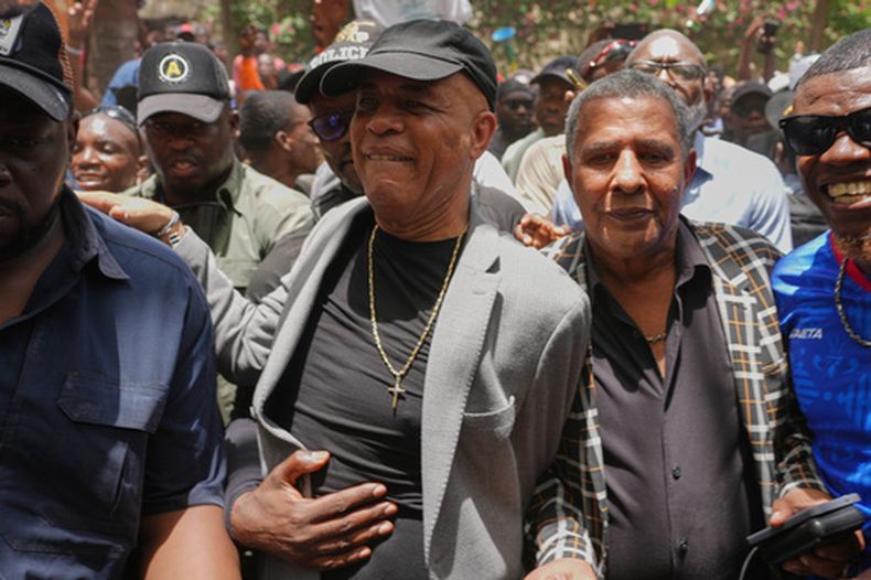 El expresidente de Haití Michel Martelly, al centro, rodeado de simpatizantes que le dieron la bienvenida, el miércoles 15 de julio de 2026, en Puerto Príncipe, Haití. (AP Foto/Odelyn Joseph)