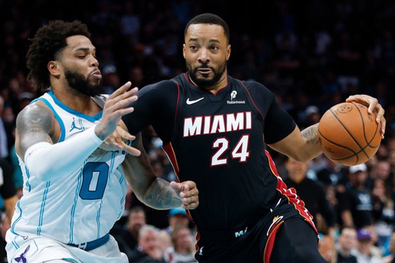 ARCHIVO - Foto del 14 de abril del 2026, el base del Heat de Miami avanza hacia la canasta frente al alero de los Hornets de Charlotte Miles Bridges en el mini-torneo de la postemporada. (AP Foto/Nell Redmond, Archivo)