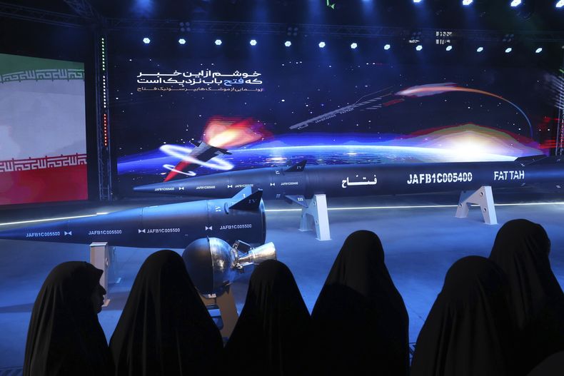 Varias mujeres miran un misil Fattah en una ceremonia en Teherán, Irán, el martes 6 de junio de 2023. Irán afirma que ha creado un misil hipersónico capaz de viajar a 15 veces la velocidad del sonido. (Hossein Zohrevand/Agencia de Noticias Tasnim via AP)