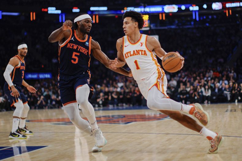 El alero de los Hawks de Atlanta Jalen Johnson avanza con el balón frente al alero de los Knicks de Nueva York Precious Achiuwa en el encuentro de la NBA del martes 5 de marzo del 2024. (AP Foto/Eduardo Munoz Alvarez)