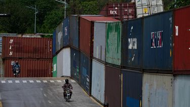 Motoristas pasan junto a contenedores de carga colocados por las autoridades para sellar una zona antes de una marcha de partidarios del ex primer ministro encarcelado Imran Khan, en Islamabad, Pakistán, el lunes 28 de septiembre de 2026. (Foto AP/Anjum Naveed)