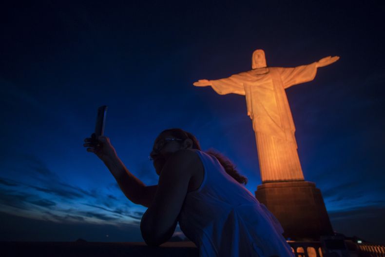 ARCHIVO - Un turista se toma una fotografía frente a la estatua del Cristo Redentor en Río de Janeiro, Brasil, el 25 de noviembre de 2017. (AP Foto/Bruna Prado, Archivo)