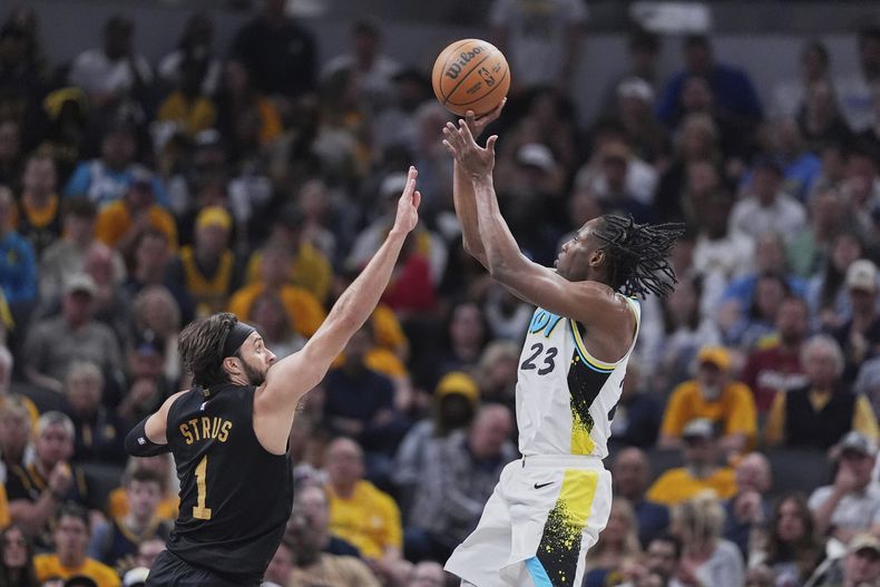 Aaron Nesmith (23), de los Pacers de Indiana, dispara a la canasta ante la marca defensiva de Max Strus (1), de los Cavaliers de Cleveland, en la primera mitad del cuarto juego de la serie de playoffs de la NBA en la Conferencia Este, el domingo 11 de mayo de 2025, en Indianápolis. (AP Foto/Michael Conroy)