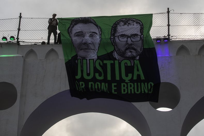 ARCHIVO – Un letrero que dice en portugués “Justicia para Dom y Bruno con imágenes del periodista británico Dom Phillips, izquierda, y del especialista indígena Bruno Pereira, en el acueducto Arcos da Lapa durante una protesta de grupos ambientalistas para pedir justicia por su muerte, en Río de Janeiro, Brasil, el 26 de junio de 2022. (AP Foto/Bruna Prado, Archivo)