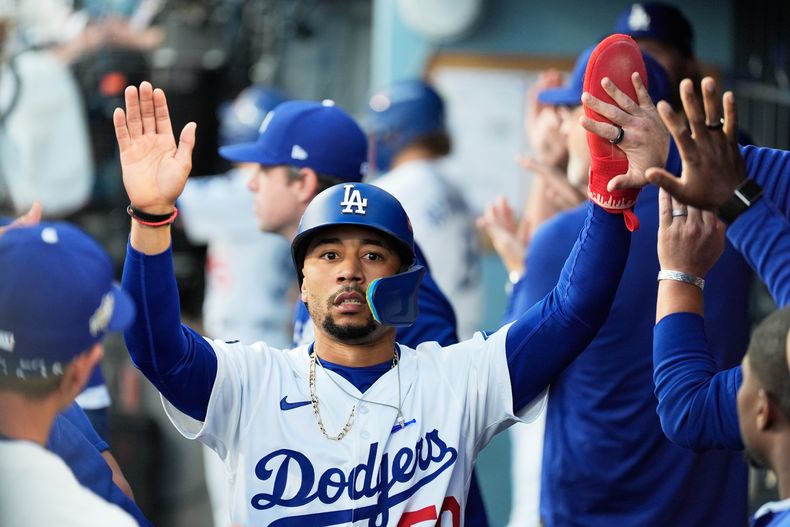 Mookie Betts, de los Dodgers de Los Ángeles, celebra en el dogout después de anotar contra los Cerveceros de Milwaukee durante la primera entrada en el Juego 4 de la Serie de Campeonato de la Liga Nacional de béisbol, el viernes 17 de octubre de 2025, en Los Ángeles. (AP Photo/Ashley Landis)