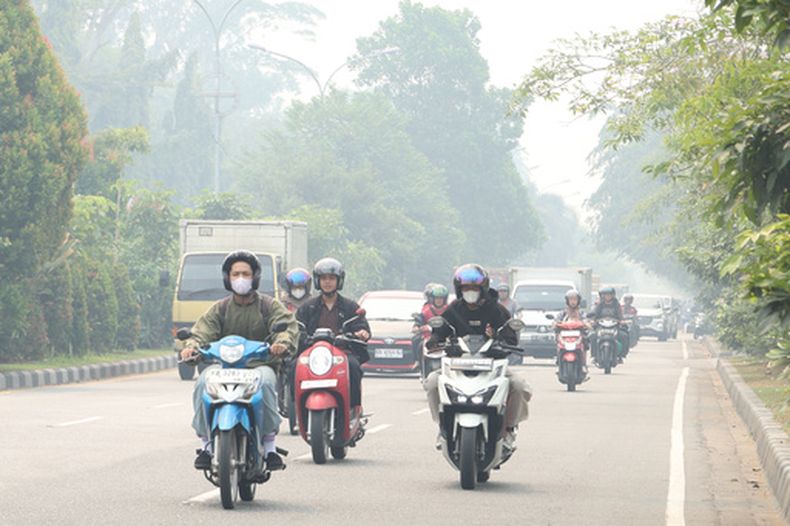 Personas en medio de la neblina en Pontianak, Kalimantan Occidental, Indonesia, el 21 de agosto del 2026. (AP foto/Stefanus Taman)