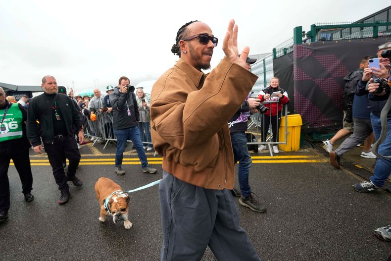 ARCHIVO - El pilot Lewis Hamilton, acompañado por su perro Roscoe, llega al paddock del Gran Premio de Gran Bretaña en el circuito de Silverstone, el viernes 5 de julio de 2024. (AP Foto/Luca Bruno)