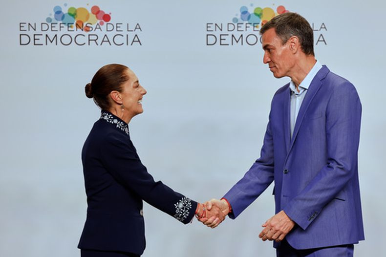 El presidente del gobierno de España, Pedro Sánchez (derecha), estrecha la mano de la presidenta de México, Claudia Sheinbaum, en la Reunión en Defensa de la Democracia, en Barcelona, el 18 de abril de 2026. (AP Foto/Joan Monfort)