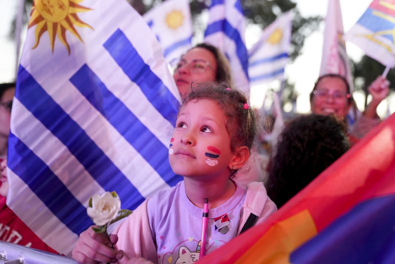 Una niña espera el inicio del acto de cierre de campaña del candidato presidencial del izquierdista Frente Amplio, Yamandú Orsi, de cara a la segunda vuelta presidencial en Las Piedras, Uruguay, el miércoles 20 de noviembre de 2024. (AP Foto/Matilde Campodónico)