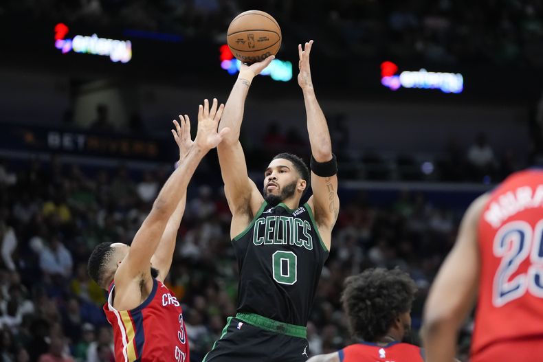 Jayson Tatum, alero de los Celtics de Boston, dispara frente a CJ McCollum, de los Pelicans de Nueva Orleáns, en el encuentro del sábado 30 de marzo de 2024 (AP Foto/Gerald Herbert)