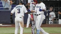 El cubano Jorge Soler, bateador designado de los Marlins de Miami, es felicitado por su compañero, el venezolano Luis Arráez, luego de conectar un jonrón de dos carreras el miércoles 17 de mayo de 2023 (AP Foto/Marta Lavandier)